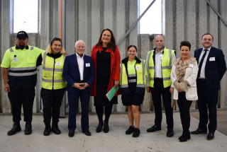 Shaun, Liana (trainees), Michael Barnett (Auckland Chamber of Commerce), Minister, Betty Heremaia Sola (trainee), Chris Carr (Carr & Haslam), Amanda Nicolle (Director Industry Partnerships) and Nick Leggett stand together in a warehouse.